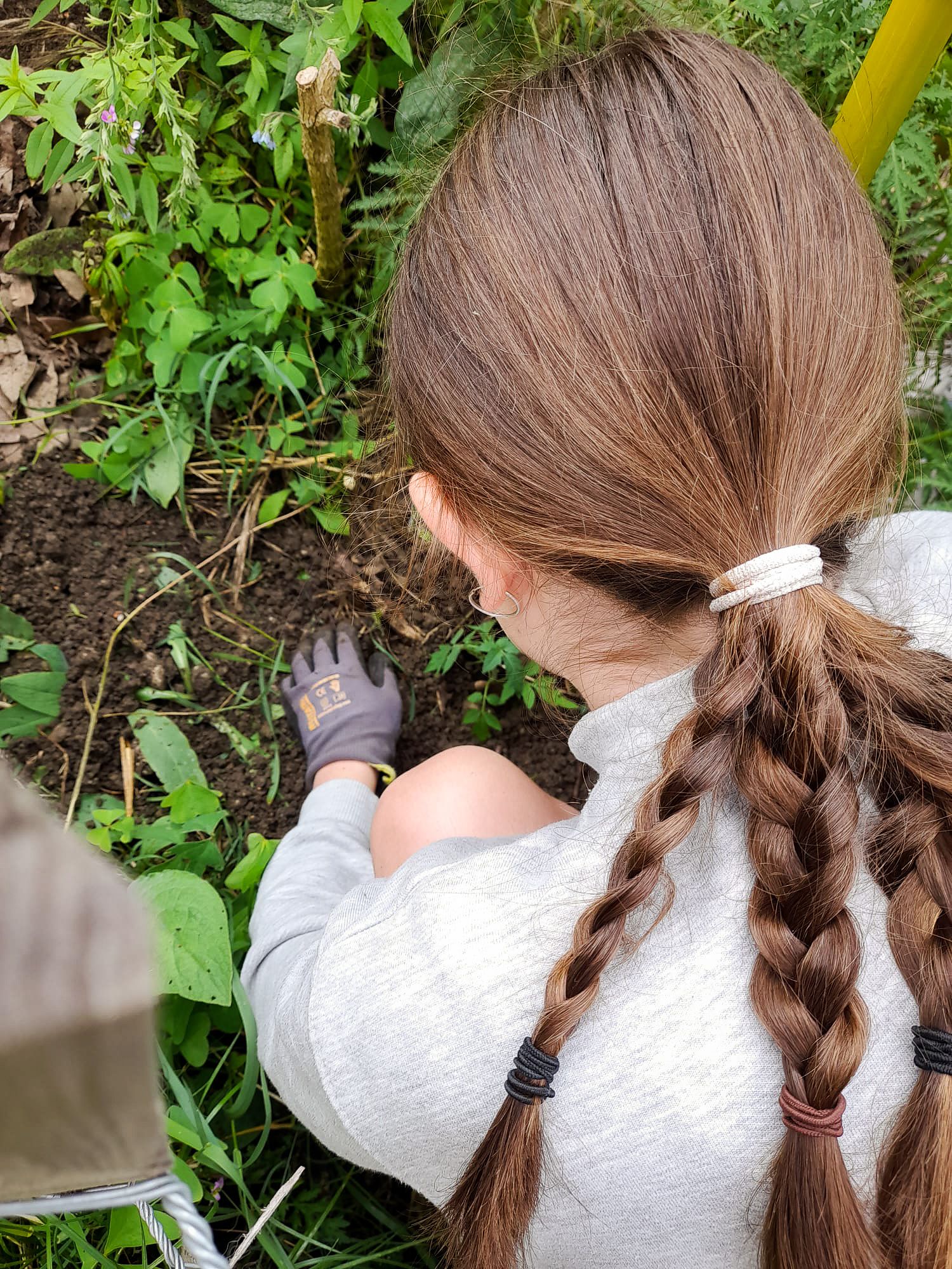 Une bénévole prend soin des plantes dans un jardin collectif.